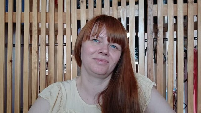 Redhead woman trying to smile while sitting in dressing room