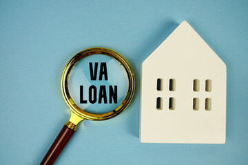 Veterans Administration Loan (VA Loan) text with house model and magnifying glass on blue background