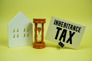 Inheritance Tax text with house model and houre glass background