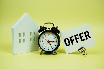 Offer text with house model and alarm clock on yellow background