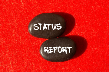Status report message written on black stones on red background. Conceptual status report symbol....