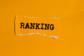 Ranking message written on ripped torn orange paper piece on orange background. Conceptual ranking...