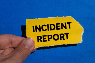 Incident report message written on ripped torn yellow paper piece on blue background. Conceptual incident report symbol. Copy space.