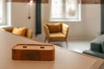 Handmade wooden candle on a light table in cozy loft interior with mustard armchairs and natural...