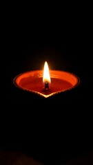 Single lit candle in dark