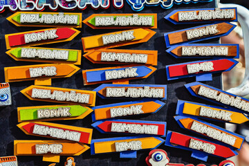 Colorful directional souvenir magnets with popular Izmir landmarks on street market display in Turkey