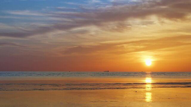 Golden sunset light glimmers across a softly rippling sea, viewed from ground level&mdash;distant boats linger near the horizon as warm reflections stretch over textured waves, capturing tranquil rhythm and