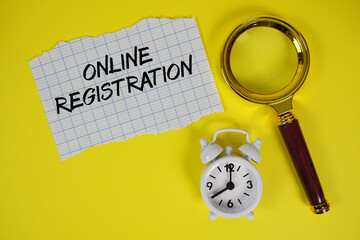 Online Registration text written on paper with magnifying glass and alarm clock
