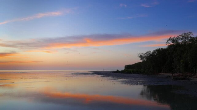 Under a radiant seaside sunset, a distant lighthouse anchors the horizon while flocks of birds soar through softly tinted skies&mdash;gentle waves ripple below, capturing peaceful motion, ambient light, and