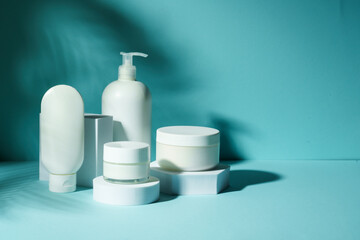 Cosmetic products at podium on blue background.