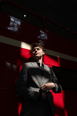 Portrait of a man against a red wall with liquid shadows