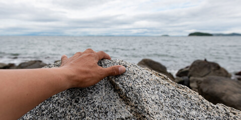 滑りやすい岩を掴む手元