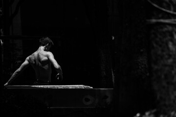 Black and white photo of a man performing a parkour trick. Extreme sports photo.