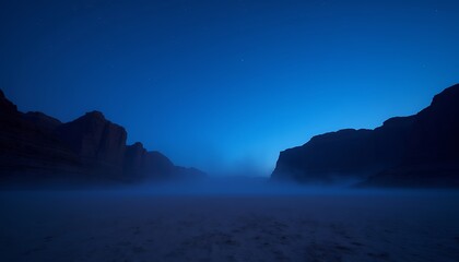Fototapeta premium Tranquil Desert Night: Dark Blue Twilight Over Misty Sand and Silhouetted Rocks