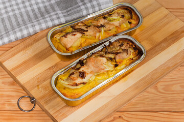 Prepared potato casserole with chicken meat in rectangular foil containers