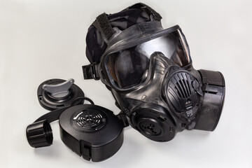 Rubber gas mask and several its accessories on gray background