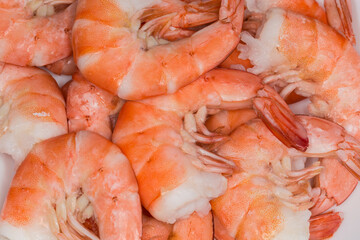 Heap of boiled unshelled tails king prawns close-up