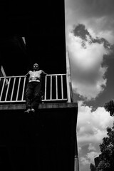 Black and white photo of a man performing a parkour trick. Extreme sports photo.