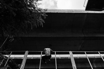 Black and white photo of a man performing a parkour trick. Extreme sports photo.