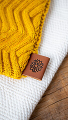 Close up of a Sunflower Leather Label on Knitwear in Yellow and White