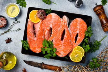 Salmon. Raw fresh salmon steaks with spices, lemon and garlic ready for baking in a metal tray....