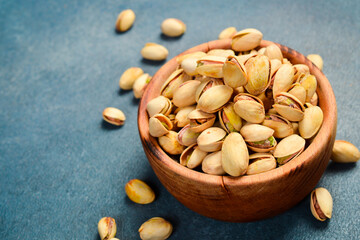 Nuts. Salted pistachios in a wooden bowl. Snacks for beer. Close-up.