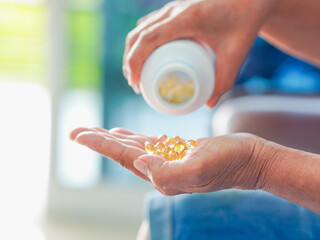 Close up hand holding bottle oil collagen for weight loss, wellness health, antioxidant. Healthy lifestyle people nutrition anti aging. Food supplements medicine for healthcare. Senior woman home care