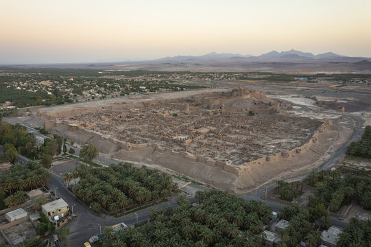 Aerial view of the ancient Arg-e Bam citadel, a city of mud-brick buildings, standing resilient against the backdrop of distant mountains, Bam, Kerman Province, Iran.