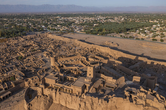 Aerial view of the eroded citadel standing as a testament to time, with the modern city sprawling in the distance, Bam, Kerman Province, Iran.