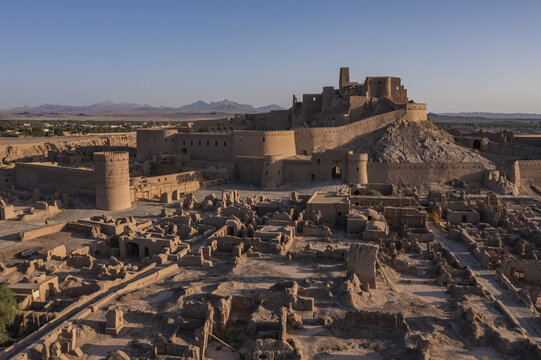 Aerial view of the ancient Arg-e Bam citadel glows with the warmth of the morning sun, a testament to enduring history, Bam, Kerman Province, Iran.