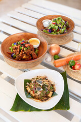 Thai Homemade Feast with Rustic Decor, A colorful spread of traditional Thai dishes served with rustic handmade decorations and cozy natural decor.