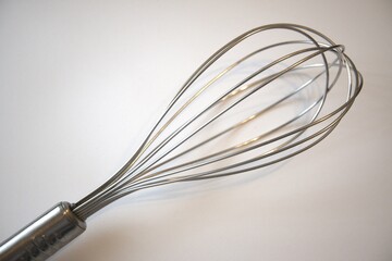 One whisk close up with white background.