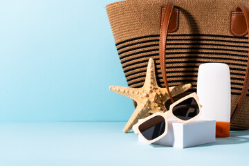 Sunglasses, sunscreen and sea shell with sunny shadows.