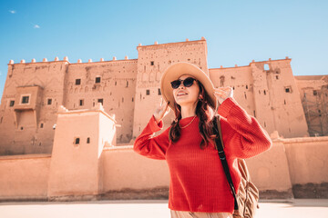 Young woman tourist is visiting the ancient Taourirt Kasbah, Ouarzazate in Morocco