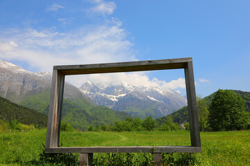 Fototapeta premium very big wooden frame and the European alps in background in Northern Italy