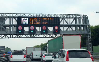 Portal with a message on motorway that means Queues A Tratti up to MILAN EAST for heavy traffic...