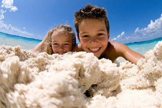 Siblings create a sandy masterpiece at the beach together