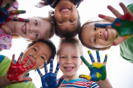 Diverse group of children display painted hands and smiles with joy