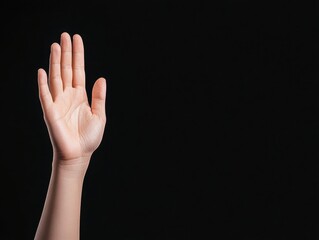Fototapeta premium Raised Hand Against Black Background