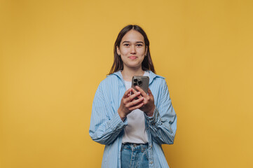 content young woman enjoys a phone call, capturing her casual joy and connection  on vibrant yellow...