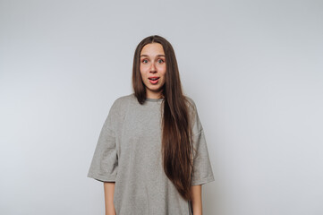 astonished woman displays surprise with wide eyes and an open mouth, accentuating her emotional...