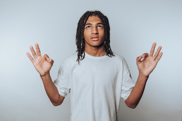young person stands with an upward gaze and hand gestures, embodying calmness and mindfulness on...