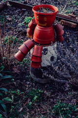 A quirky humanoid made from red plant pots stands in a whimsical garden in Nikiszowiec, Katowice,...