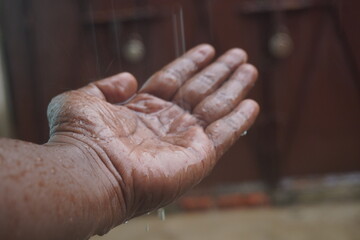 water drop on hand : A crystal-clear water drop resting on a hand symbolizes purity, life,...