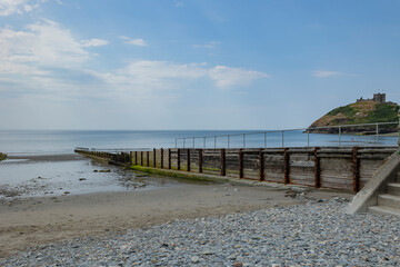 Wooden groynes stretching across a sandy beach
