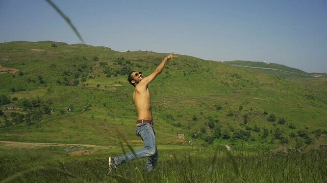 A man throwing a T-shirt in the meadows of Rayta Hills, nestled in the Aravalli Mountains near Udaipur, Rajasthan, India.