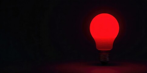 Close-up of a single red lightbulb, glowing intensely against a dark background The vibrant red hue is striking and eye-catching, perfect for concepts of urgency, warning, or danger , bright, light