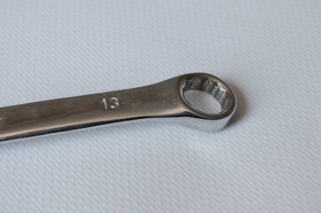 metal wrench with size marking 13 on a white background, ideal for themes like repair, mechanics,...