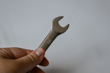 metal wrench with size marking 13 on a white background, ideal for themes like repair, mechanics,...