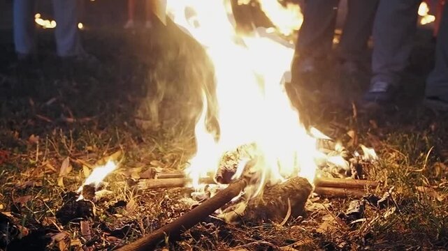 Bonfire of bundled torches blazing on a bed of dry grass during the lilanje ritual in Loznica, Serbia, sending sparks and dancing flames into the night.